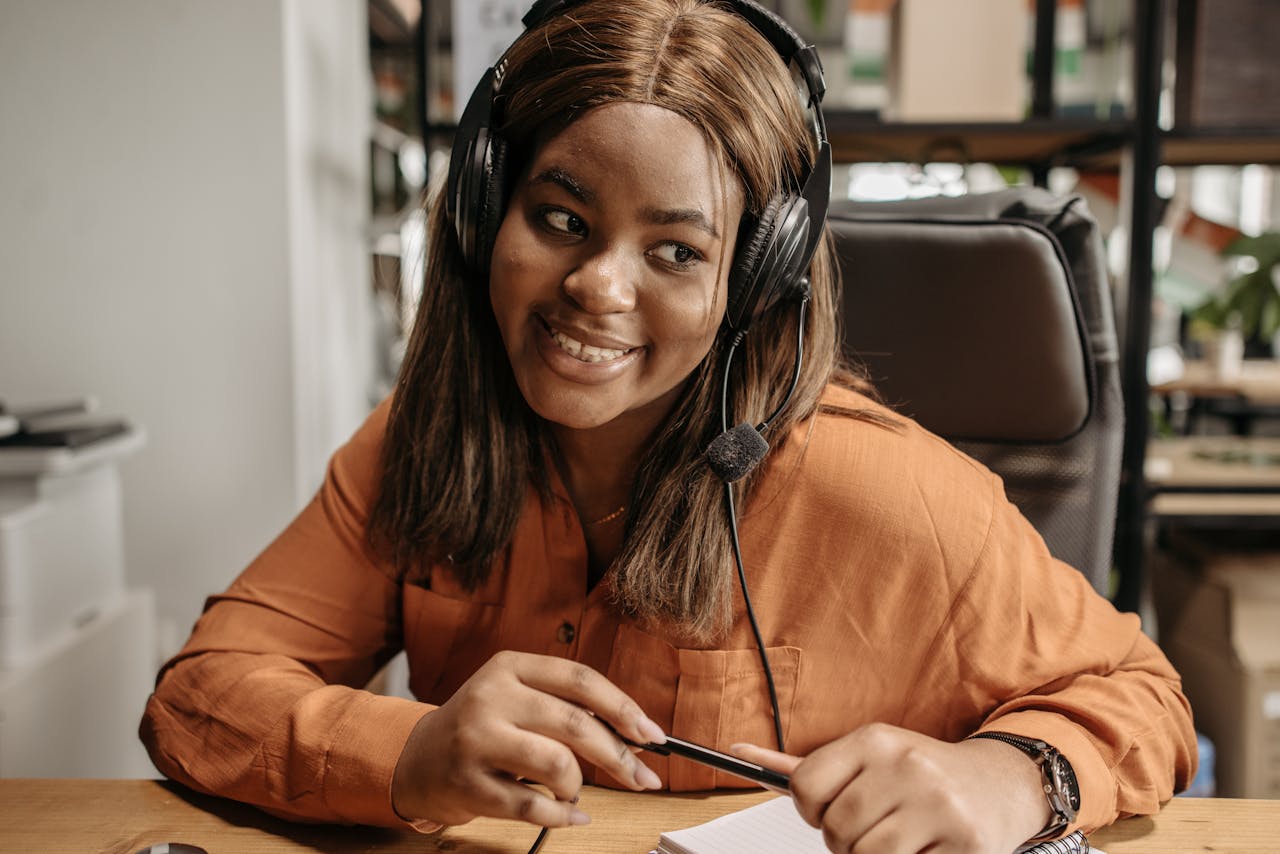 services-01 A cheerful customer support agent with a headset provides assistance in an office setting.